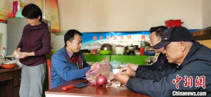 圖為扶貧路上“臨時(shí)一家人”準(zhǔn)備午餐?！∥航ㄜ?攝