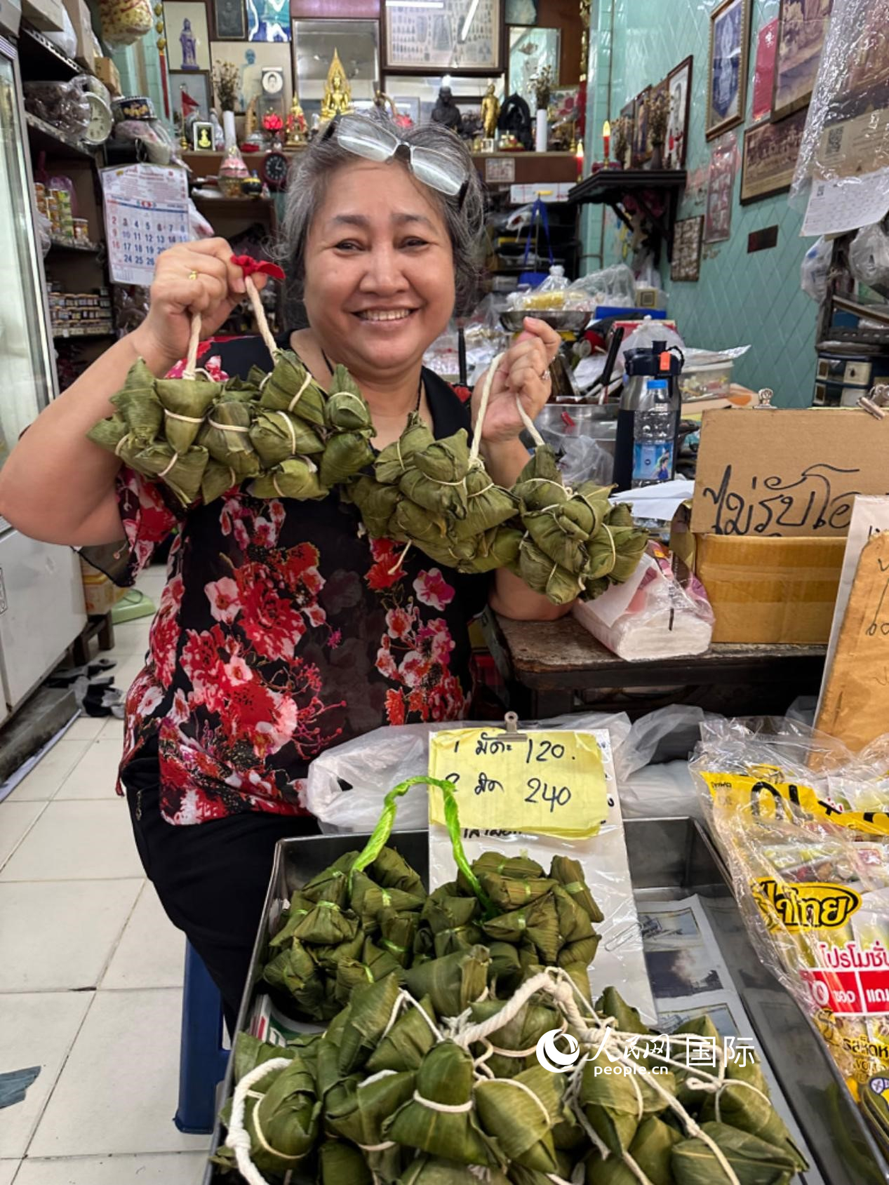 商家向顧客介紹“吉掌”（粽子的一種，一串一串，個頭較小）。人民網(wǎng)記者 簡承淵攝