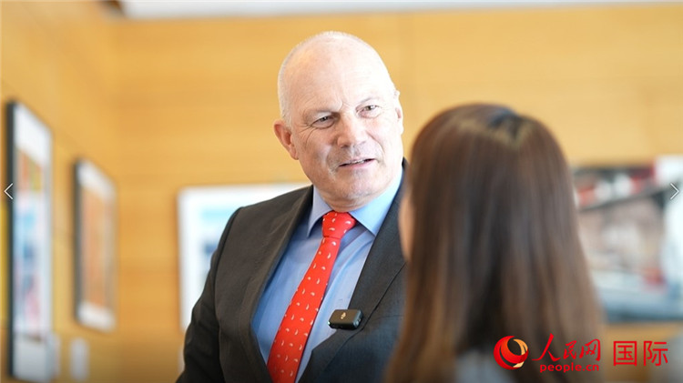 瑞士駐華大使白瑞誼介紹使館內(nèi)陳列的照片。人民網(wǎng) 彭昱凱攝