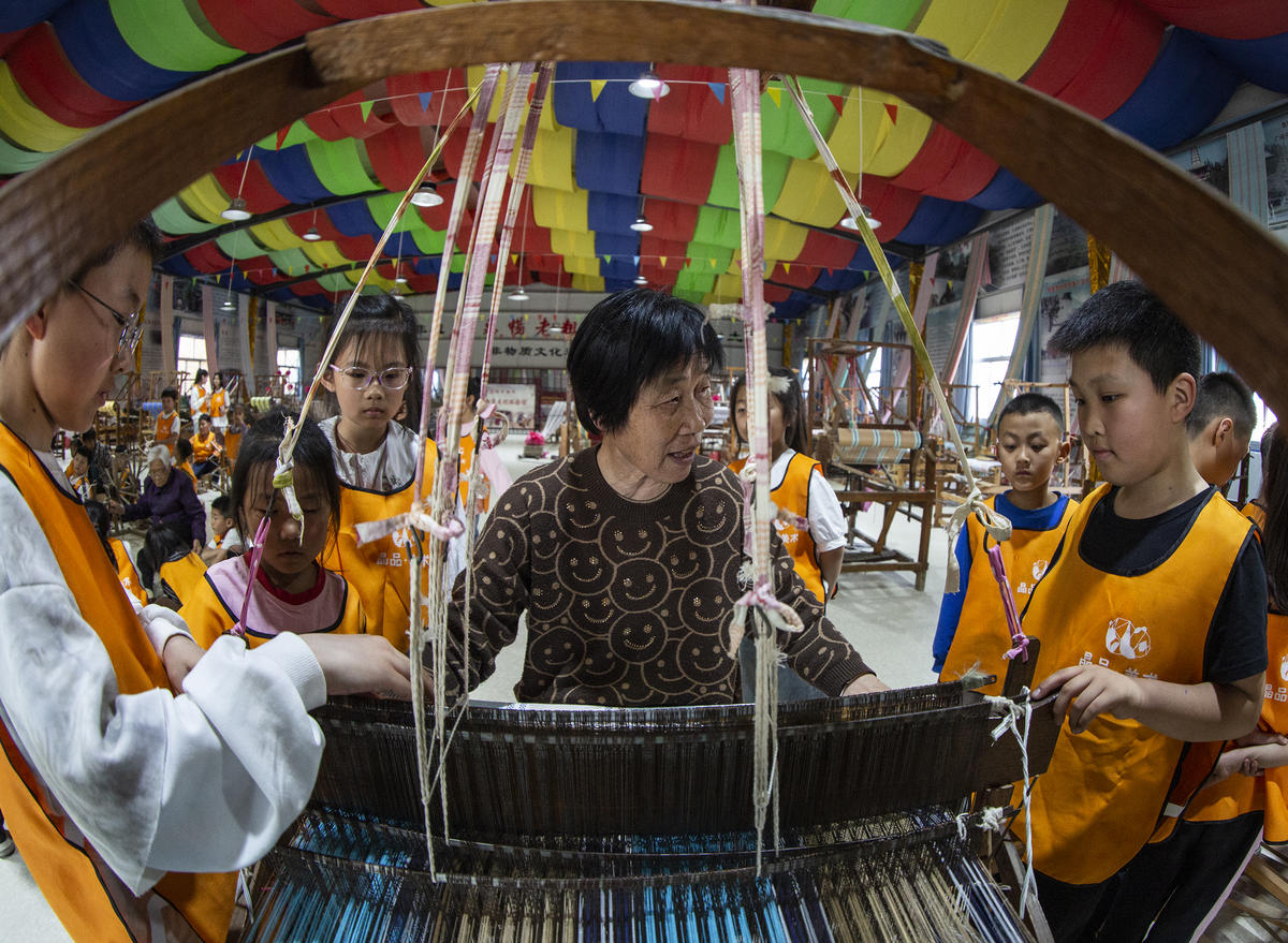 5月1日，在山西省永濟市開張鎮(zhèn)東開張村的惠暢土布文化園，土布制作技師教游客織布技藝。 來源：人民圖片網(wǎng)