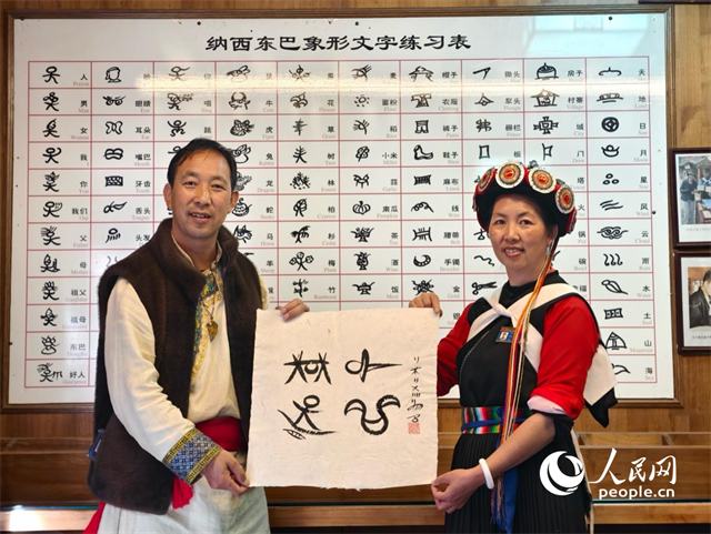 人民網(wǎng)“行進中國”云南調(diào)研采訪團走進麗江，和閏元現(xiàn)場用東巴文寫下“行進中國”。人民網(wǎng)記者 符皓攝