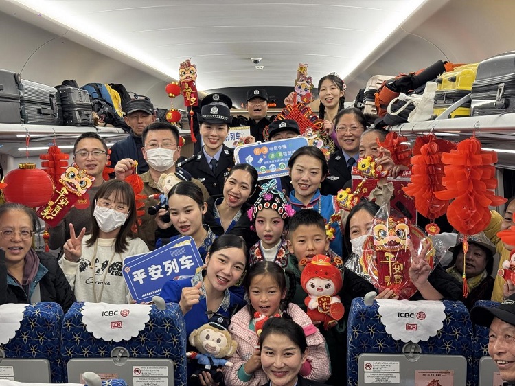 春節(jié)期間，在中老鐵路磨萬（磨丁—萬象）段，鐵路客運員工與乘客合影留念。李加勇攝