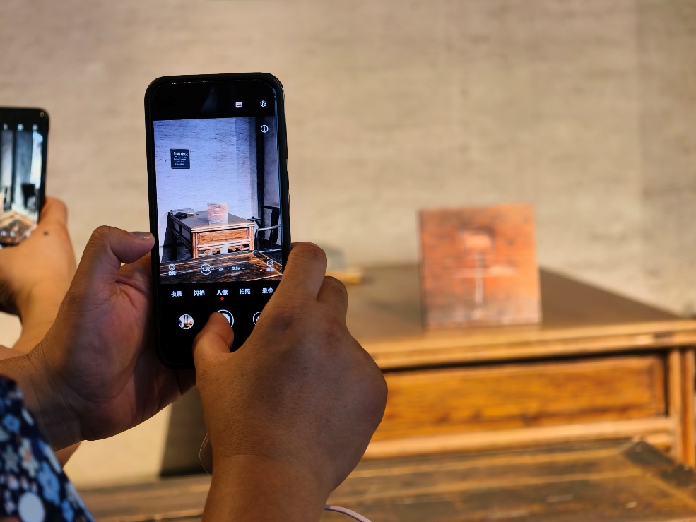 2025年7月15日，暑期研學(xué)團(tuán)小朋友在浙江省紹興市三味書屋拍攝魯迅讀書座位及課桌上的“早”字。受訪者供圖