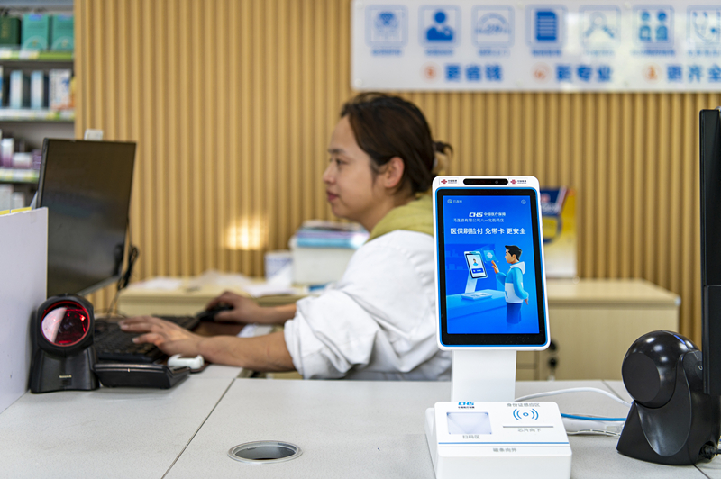 2024年4月10日，浙江金華市區(qū)一家民眾大藥房柜臺(tái)上設(shè)置著醫(yī)?！八⒛樦Ц丁睓C(jī)器，群眾看病更加便利。