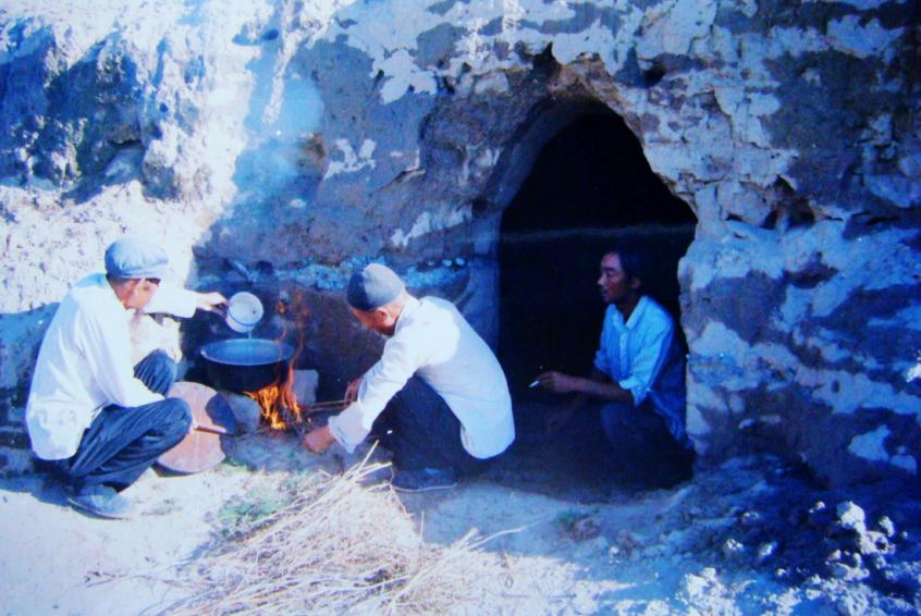 1983年，“六老漢”一代治沙人在“地窩子”生活做飯。新華社發(fā)（八步沙林場供圖）
