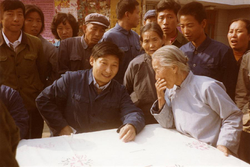 1983年，時(shí)任河北正定縣委書記的習(xí)近平（前排居中），臨時(shí)在大街上擺桌子聽取老百姓意見。