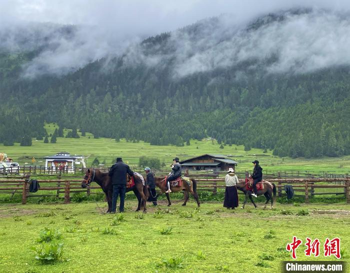 6月10日，游客在魯朗小鎮(zhèn)高山牧場景區(qū)體驗騎馬。　冉文娟 攝