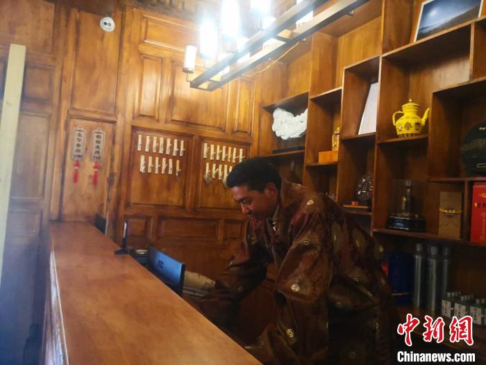 圖為桑杰才讓用電腦處理財務(wù)?！∈缝o靜 攝