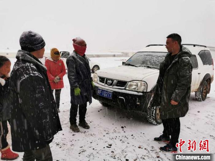 圖為扎西鬧吾(右一)與當地牧戶交談。郵儲銀行青海省分行供圖