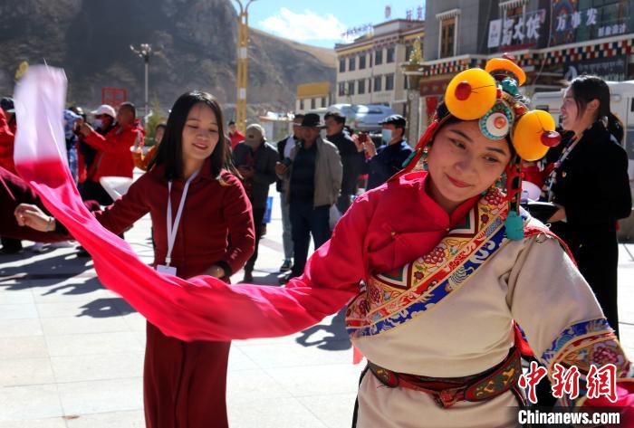 圖為中外記者向當(dāng)?shù)孛癖妼W(xué)習(xí)民族歌舞文化?！?zhí)砀?攝