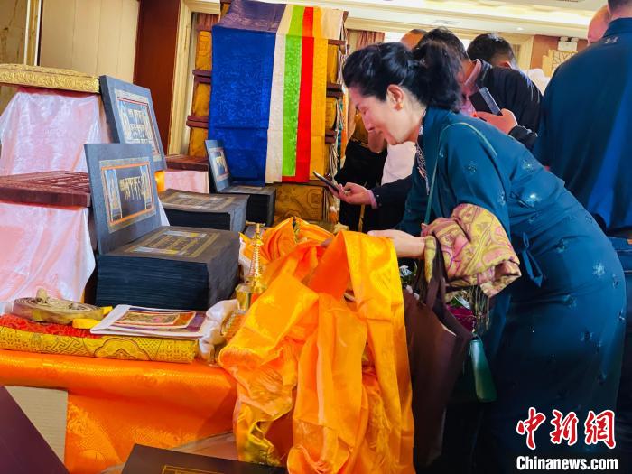 圖為現(xiàn)場藏族民眾向黃金書寫的大藏經(jīng)《甘珠爾》敬獻(xiàn)哈達(dá)?！O睿 攝