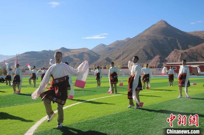圖為青海師范大學(xué)附屬玉樹(shù)實(shí)驗(yàn)學(xué)校學(xué)生在綠茵場(chǎng)跳起囊謙古舞—卓根瑪。　程雨 攝