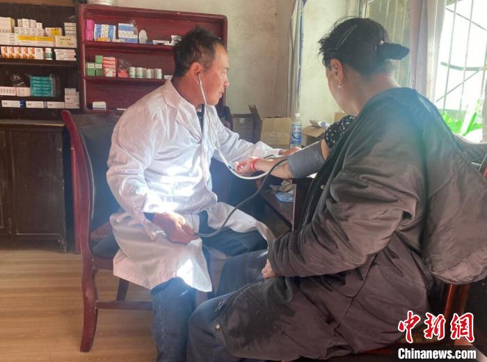 索木滾(左)為村民看病?！∪捞量h委宣傳部供圖
