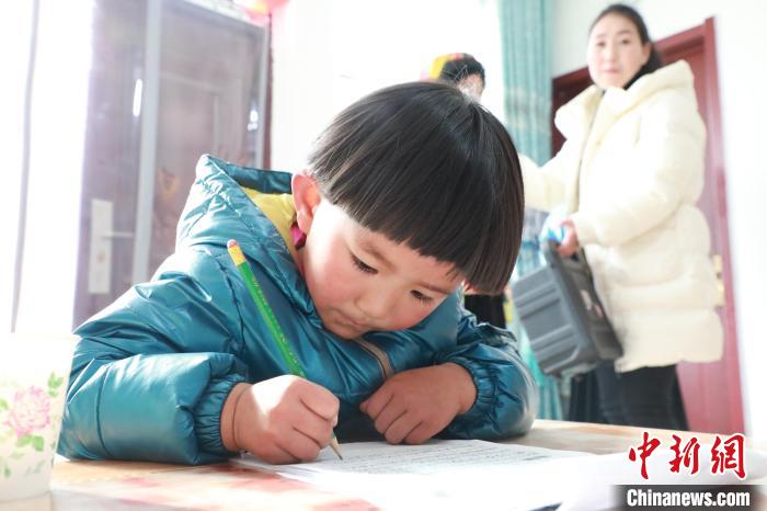 孩子們?cè)诩议T口上學(xué)，是楊周馬草搬入蘭州新家最為開心的事情。小女兒楊洋正在學(xué)習(xí)寫數(shù)字?！∥航ㄜ?攝