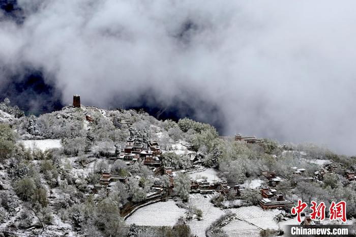 雪后的藏寨和碉樓構(gòu)成美麗的雪景?！〗党鯘衫?攝