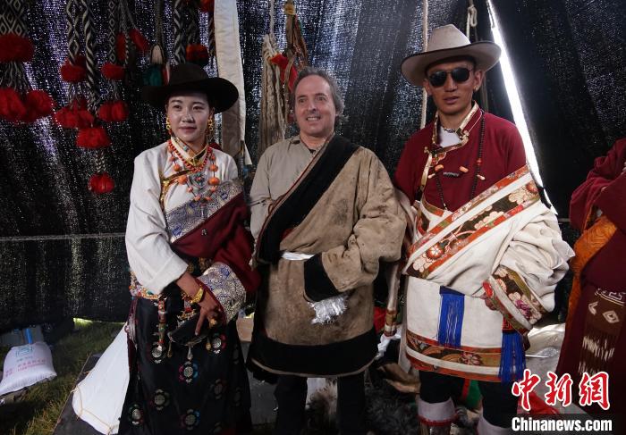 圖為一名外籍攝影師(中)身穿藏服和藏族民眾合影留念。　馬銘言 攝