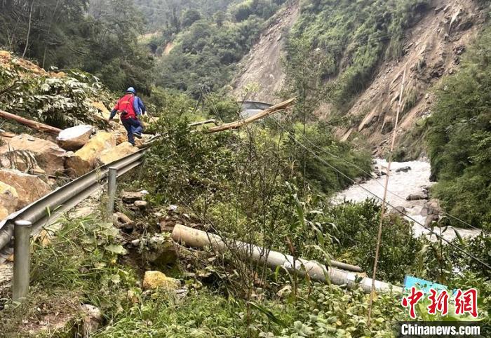 電力搶險人員快速通過危險路段，旁邊是受損的電力線路 四川電力供圖