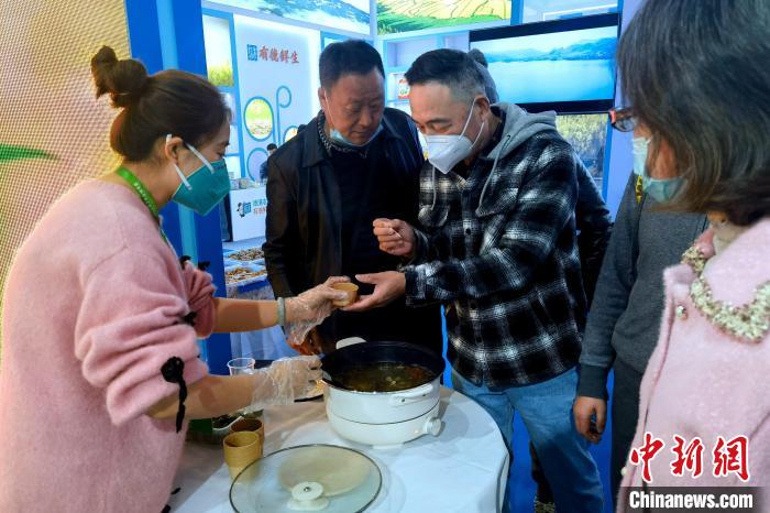圖為杭州市民品嘗茶卡羊肉?！±铍h 攝
