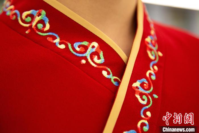 圖為新制服領(lǐng)口點綴有蒙古特色的烏力吉紋繡花?！±罾?攝