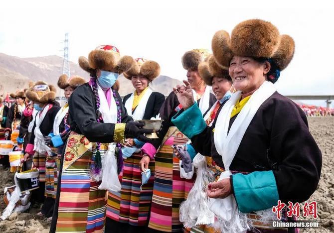 資料圖：西藏自治區(qū)拉薩市曲水縣才納鄉(xiāng)協(xié)榮村參加春耕儀式的村民互敬青稞酒。按照傳統(tǒng)，當(dāng)?shù)卮迕裆碇?jié)日盛裝，舉行隆重的儀式，祈福一年的豐收。<a target='_blank' ><p  align=