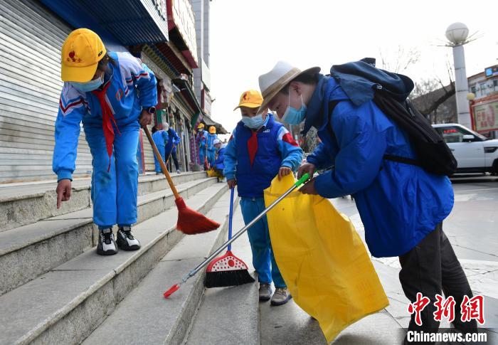 圖為拉薩市小學(xué)生打掃街道?！∝暩聛硭?攝