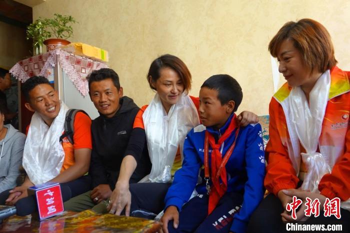 圖為世界冠軍在拉薩進(jìn)行家訪，與青少年運(yùn)動員聊天?！∪轿木?攝