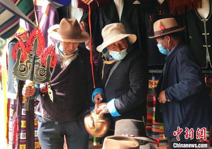 圖為三位藏族老人在集市上聊天交談?！∪轿木?攝