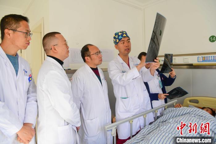 圖為何蔚副主任醫(yī)師(站右二)及團隊討論患者病情?！∝暩聛硭?攝