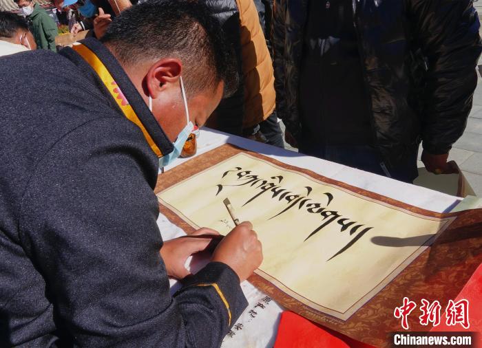 圖為書(shū)法家展示藏文書(shū)法?！∪轿木?攝