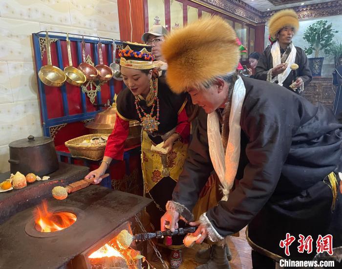 圖為人們在火上烤節(jié)日美食“結(jié)達(dá)”。　冉文娟 攝