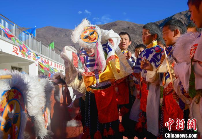 圖為加查縣安繞鎮(zhèn)小學(xué)學(xué)生在試穿藏戲面具?！∝暩聛?lái)松 攝