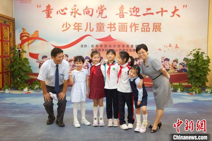 圖為與會(huì)嘉賓與入選畫(huà)作的“小作者”們?cè)谡褂[上合影?！≈袊?guó)藏學(xué)研究中心供圖