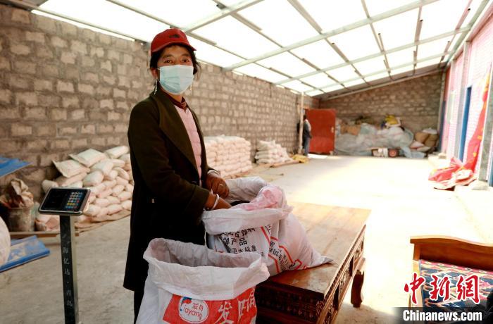 圖為寧重崗村村民扎西才措把自家的油菜籽送到合作社銷(xiāo)售?！〖卫杩h融媒體中心供圖