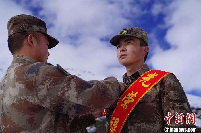 排長(zhǎng)王朝偉(圖左)給退伍老兵佩戴大紅花?！∥鞑厣侥宪姺謪^(qū)某團(tuán)供圖