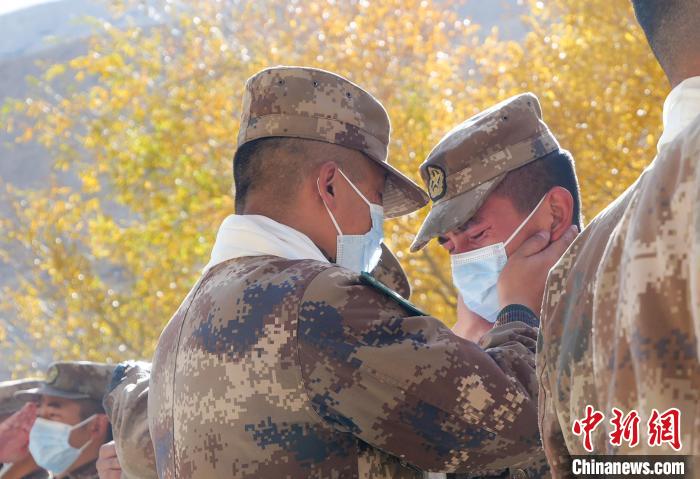 圖為什布奇邊防連退伍老兵與戰(zhàn)友相擁而泣，依依惜別?！⌒觳?攝