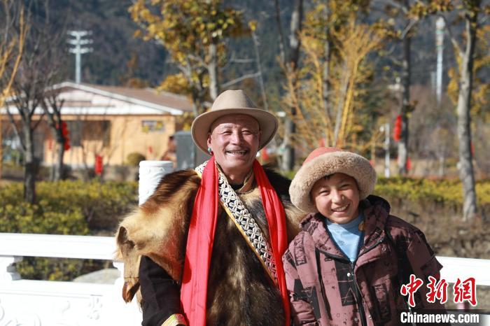圖為林芝市巴宜區(qū)布久鄉(xiāng)仲果村村民桑杰與孫子一起參加藏歷新年活動(dòng)?！埩?攝