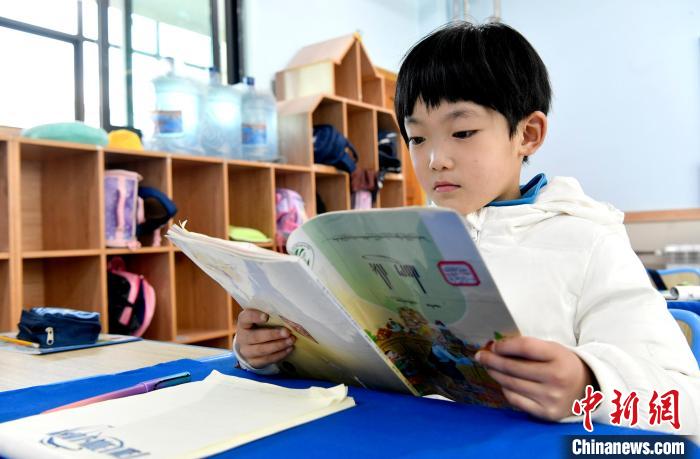 3月14日，西藏拉薩市第一小學(xué)一年級(jí)六班學(xué)生丁增樂吉在閱讀藏語課本。　李林 攝