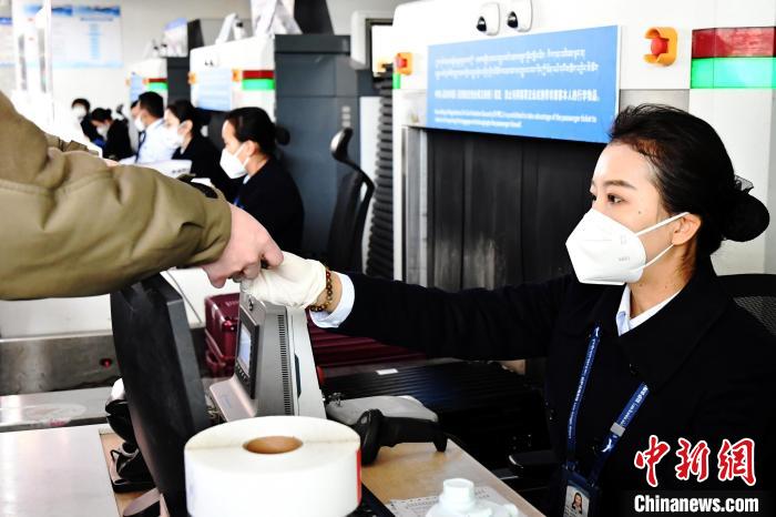 圖為機(jī)場工作人員為旅客辦理行李托運(yùn)?！≈芎?攝