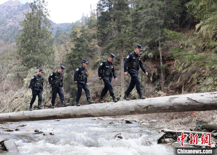 山南邊境管理支隊玉麥邊境派出所民警邊境巡邏途中走過河道上“獨木橋”。　鄭琦山 攝
