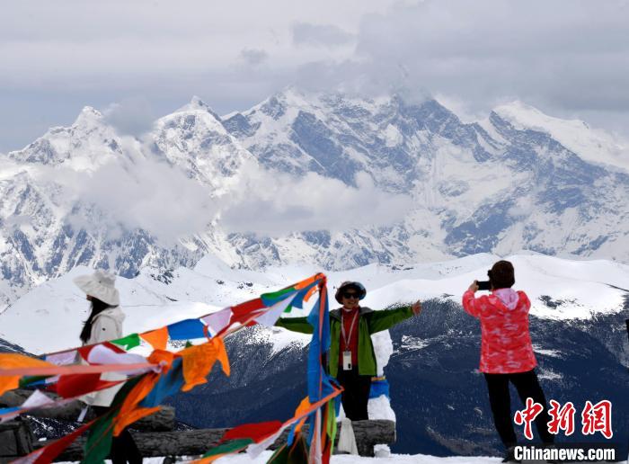 圖為5月14日，西藏林芝色季拉山觀景臺，游客與南迦巴瓦峰合影。　李林 攝