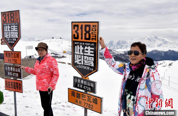 圖為5月14日，西藏林芝色季拉山觀景臺，游客與南迦巴瓦峰合影?！±盍?攝