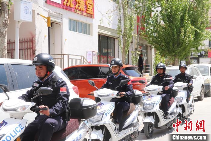 民警騎著電瓶車在轄區(qū)巡邏走訪。　黃創(chuàng)偉 攝